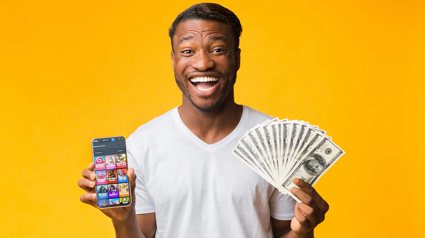 Young black man playing Stake on phone with money on his hand