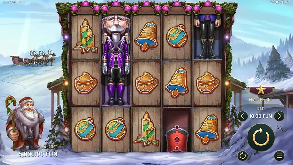 Big Stack Nutcrack base game showing reels with bells, cups, ornaments, and giant nutcracker symbols in a snowy village.